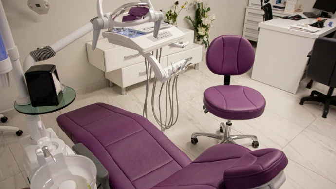 a purple chair sitting in a room next to a desk